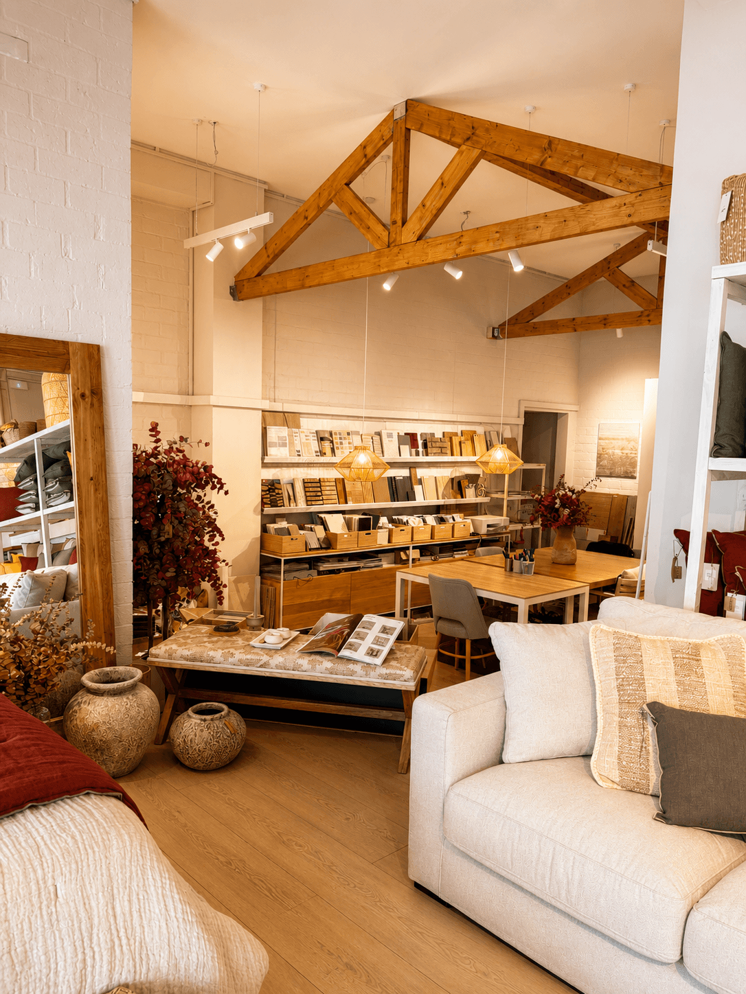 Showroom d'At Moment amb bigues de fusta, llums i zona de treball
